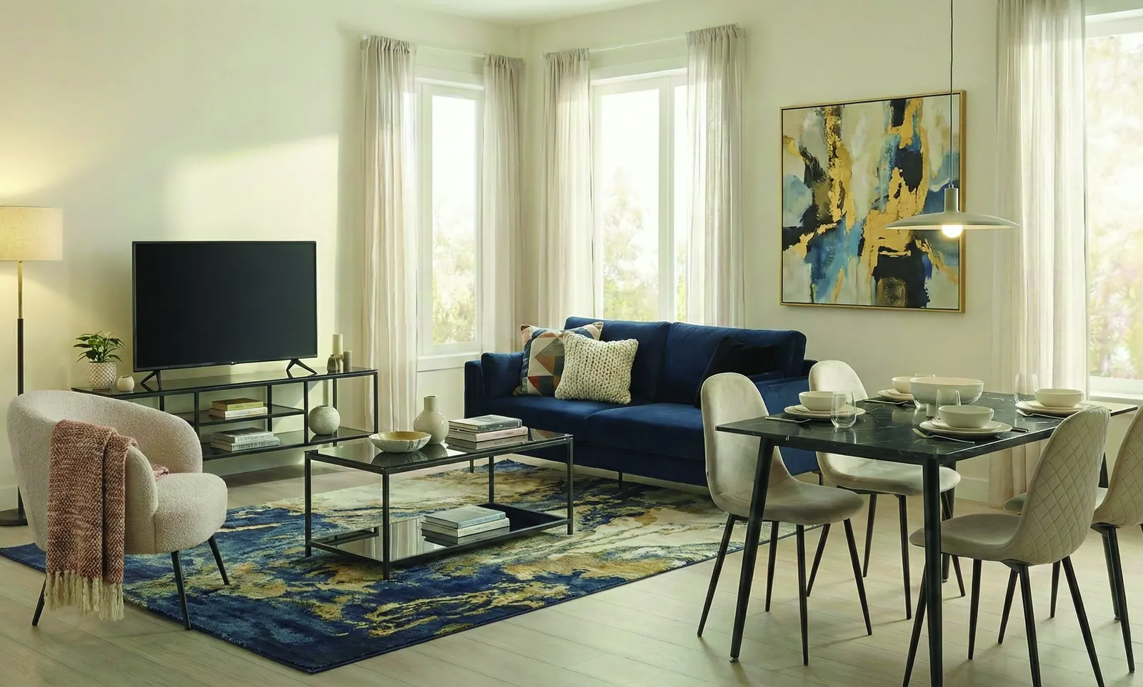 The same living room styled with a navy sofa and gold artwork